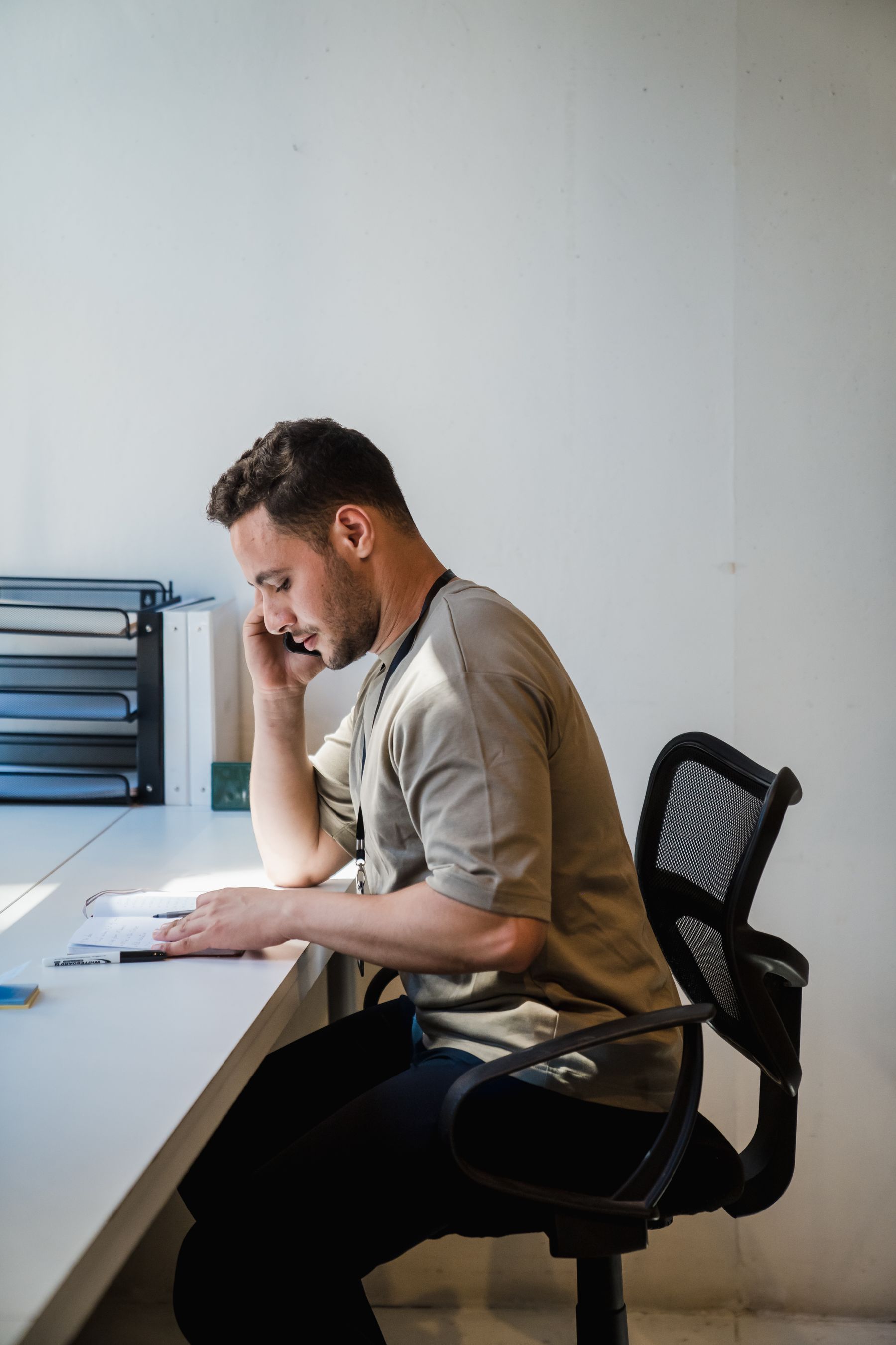 Mann telefoniert am Schreibtisch im Büro