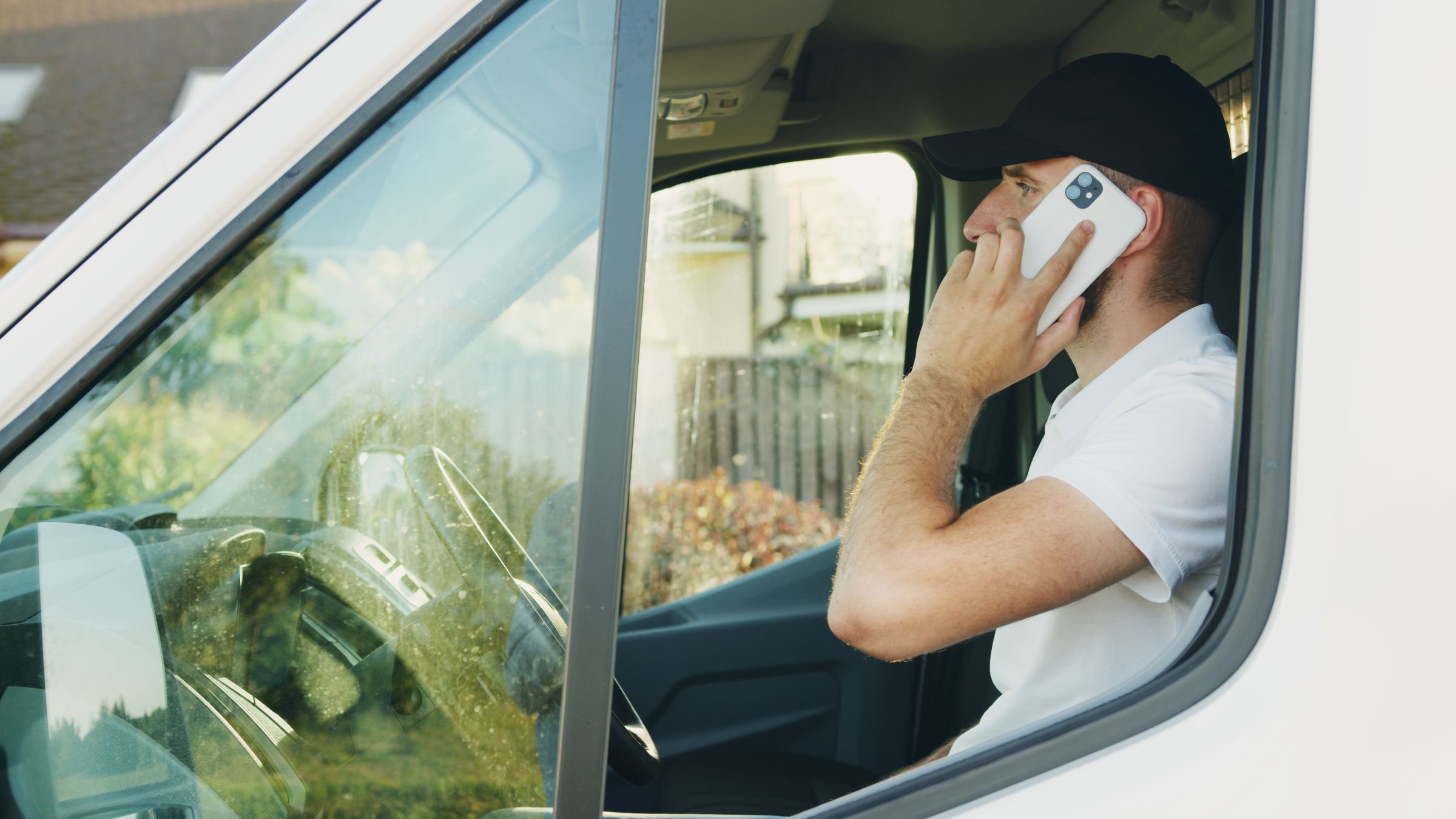 Handwerker telefoniert im Transporter